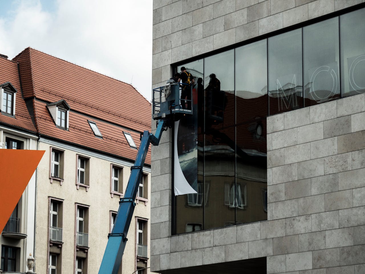 services-01 Workers on a lift install a large banner on a modern building in Wrocław, Poland.