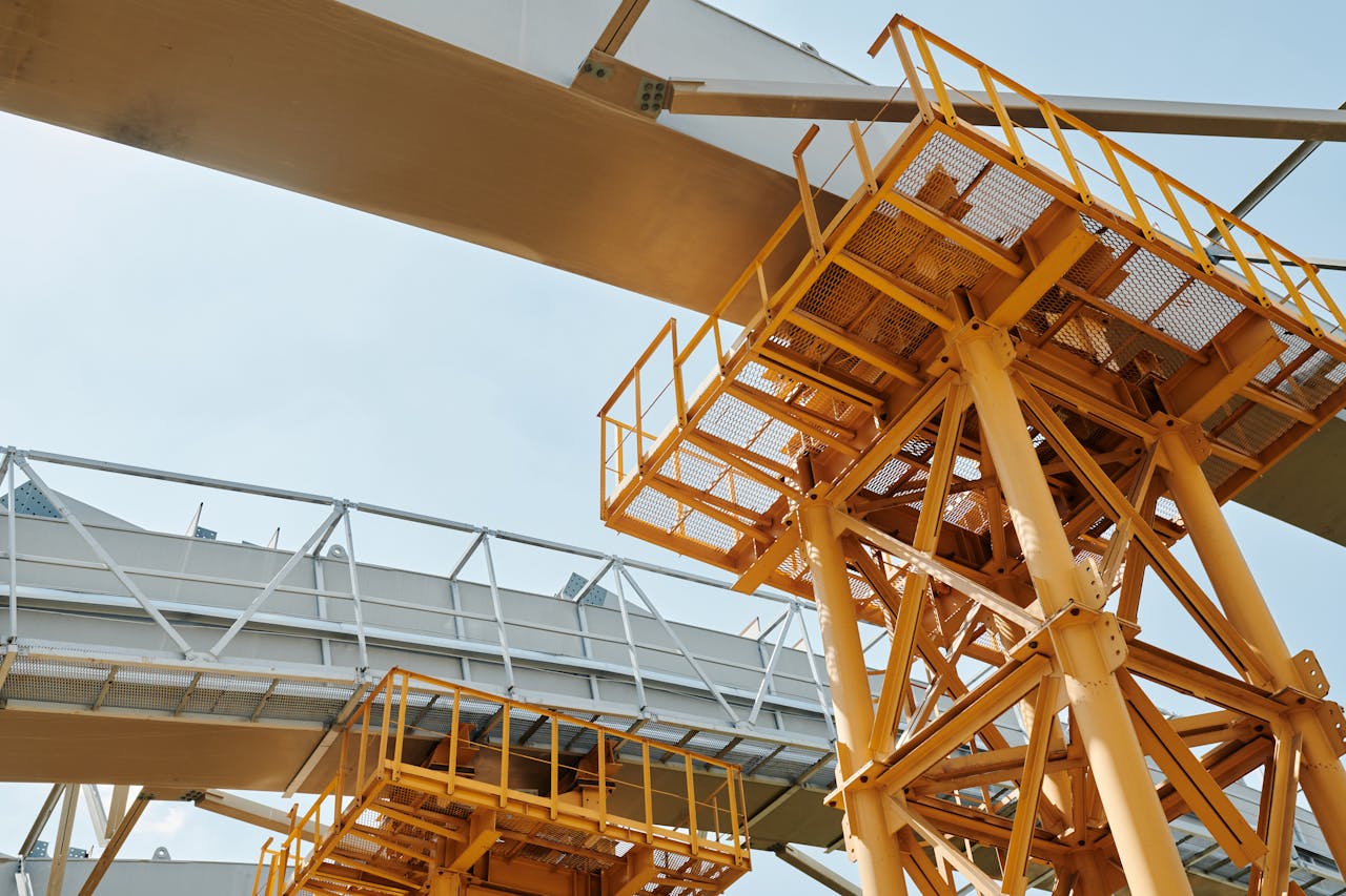 hero-img-01 Yellow scaffolding structure with metal framework against clear sky.